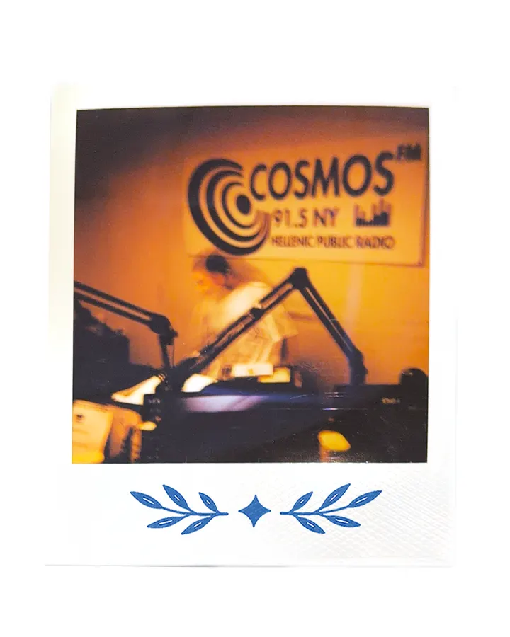 The Cosmos FM sign on the studio wall, a microphone and the desk below it.