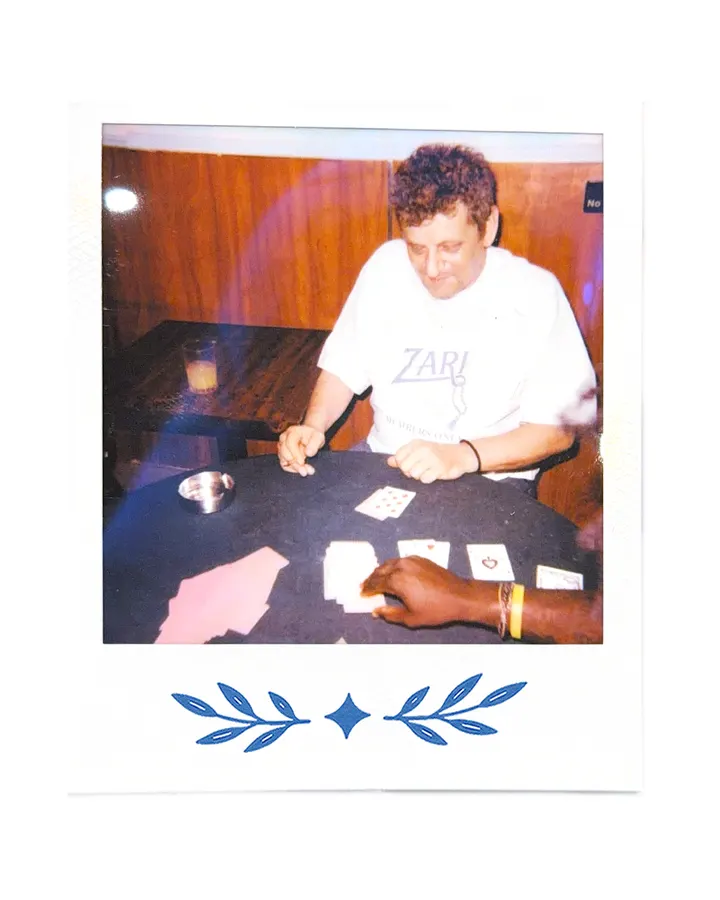 A member in the Zari tee dealing cards across a table.